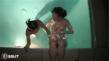 Две голые подружки плавают в бассейне с подсветкой